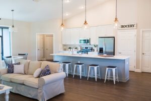 Open concept farmhouse living room and kitchen with large island, bar seating, and pendant lighting