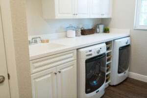 Farmhouse laundry room with built-in cabinetry, washer and dryer, and countertop workspace