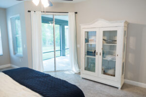 Farmhouse bedroom with large windows, sliding glass doors, and soft neutral finishes