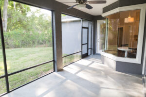 Screened-in patio with ceiling fan and views of backyard for outdoor relaxation