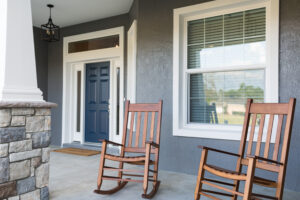 Farmhouse front porch with rocking chairs, columns, and inviting entryway