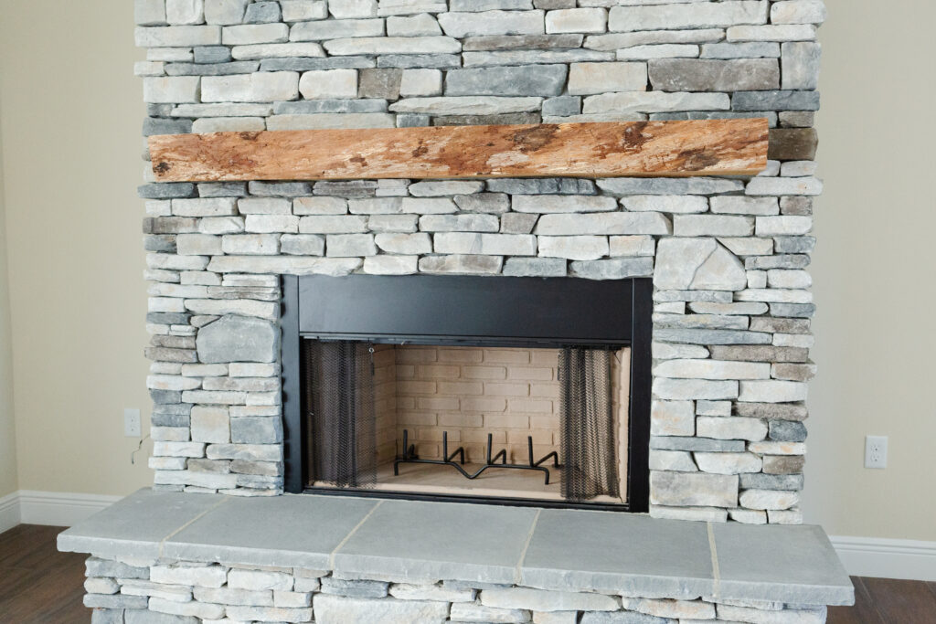 stone fireplace with wood mantel in custom country home living room