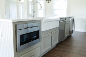 kitchen island with farmhouse sink and built in microwave drawer