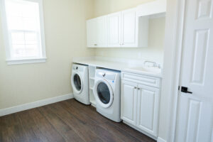 laundry room with washer dryer and custom cabinets in custom home