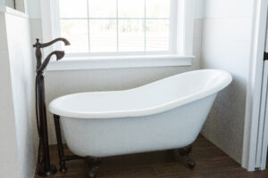 freestanding bathtub near window in custom bathroom with natural light