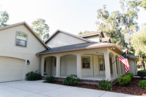 Custom ranch-style home exterior with wraparound porch in Irish Acres Ocala