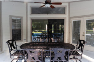 Covered outdoor patio with seating area overlooking backyard