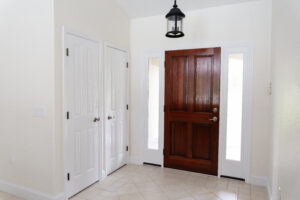 Front entry foyer with wood door and tile flooring in custom home