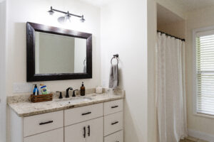 Bathroom vanity with large mirror, modern fixtures, and neutral finishes