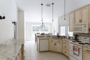 Open kitchen with large island, pendant lighting, and granite countertops