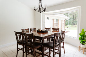 Dining area with large window, chandelier, and wood table in custom home