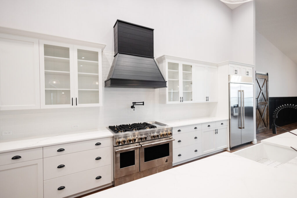 white farmhouse kitchen with black range hood and professional gas stove