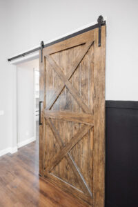 custom wood sliding barn door with black hardware in farmhouse home