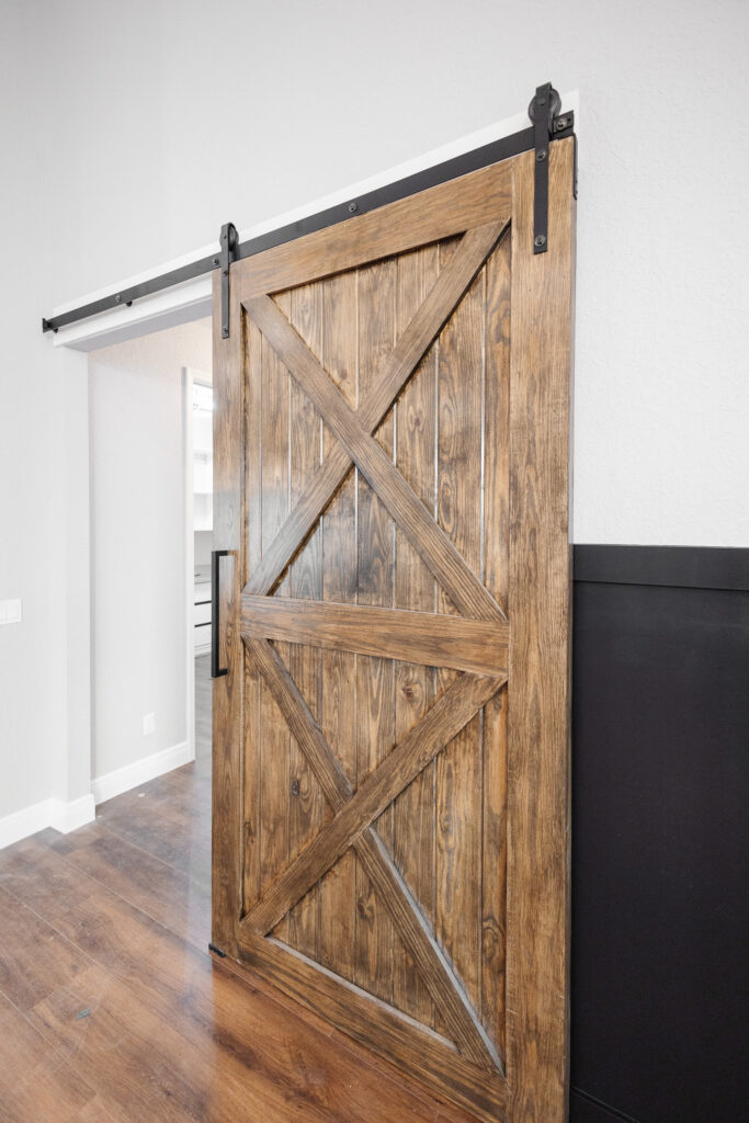 custom wood sliding barn door with black hardware in farmhouse home