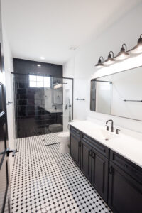 bathroom with glass shower black tile and double vanity farmhouse style