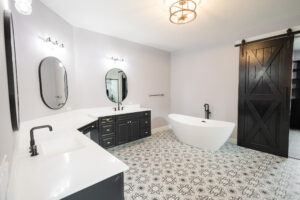 freestanding soaking tub in modern farmhouse bathroom with patterned tile floor