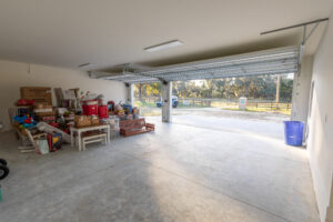 Attached garage opening to fenced pasture and horse acreage at a custom farmhouse in Morriston, FL