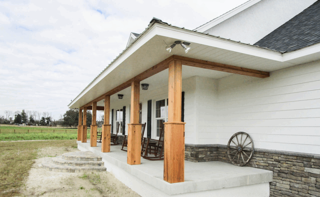 Exterior of a country-style home featuring stone siding, white trim, and a gabled roof.