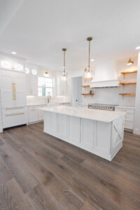 Open concept modern farmhouse kitchen with large island and pendant lighting in Morriston Florida custom home