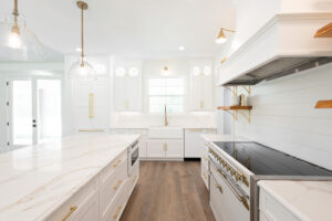 Custom modern farmhouse kitchen with gas range, floating shelves, and white cabinetry in Morriston Florida