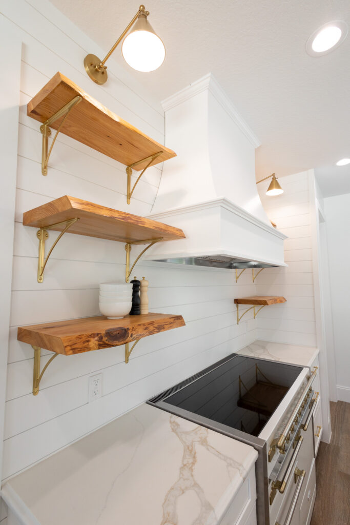 Modern farmhouse kitchen with floating wood shelves and pot filler in Morriston Florida custom home