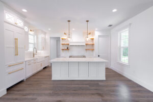 Bright modern farmhouse kitchen with large island and pendant lighting in custom Morriston Florida home