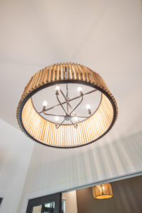Modern round ceiling light fixture with wood trim and metal design in Ocala Florida custom home