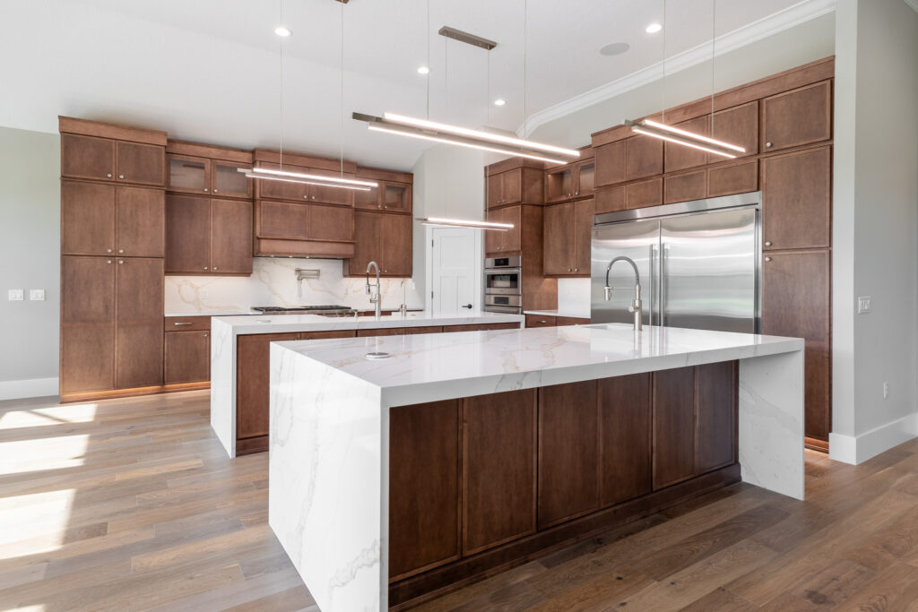 Open concept kitchen in Juliette Falls featuring oversized white quartz island, custom wood cabinetry, and modern finishes by Curington Homes.