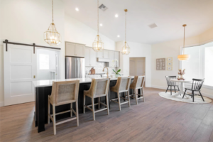 Custom kitchen with quartz island, barstool seating, and bay window dining nook in a Curington Home in Ocala, FL