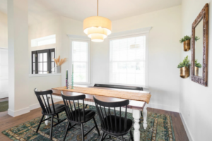 Custom dining area with black spindle chairs, white table, pendant lighting, and large windows in a Curington Homes build in Ocala, Florida