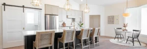 Custom kitchen with quartz island, barstool seating, and bay window dining nook in a Curington Home in Ocala, FL