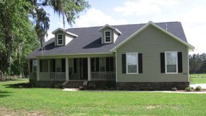 A green modern farmhouse with porch in Ocala, Florida