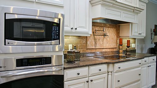 Part of a kitchen in a modern farmhouse with stainless steel appliances and granite counter tops.
